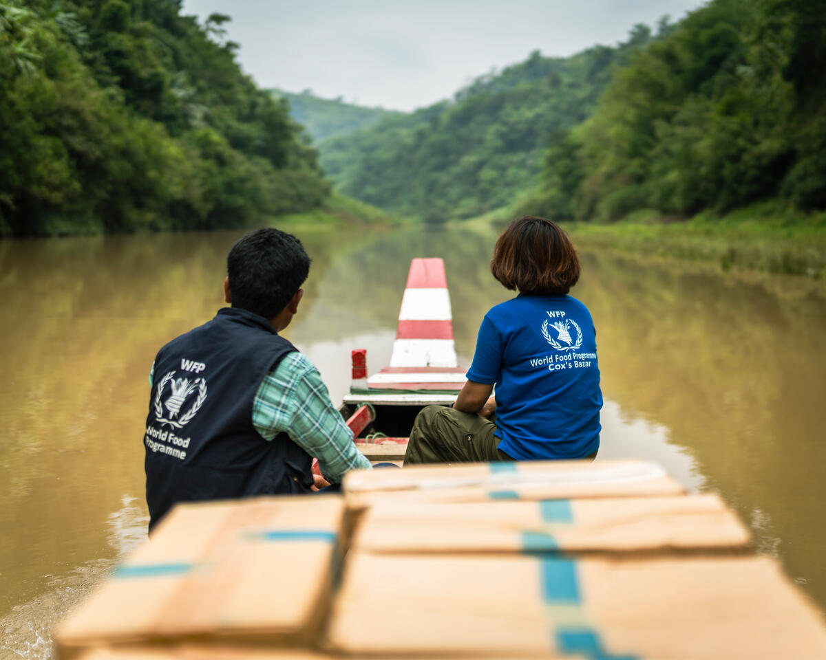 WFP staff carrying boxes of packaged biscuits on boat 