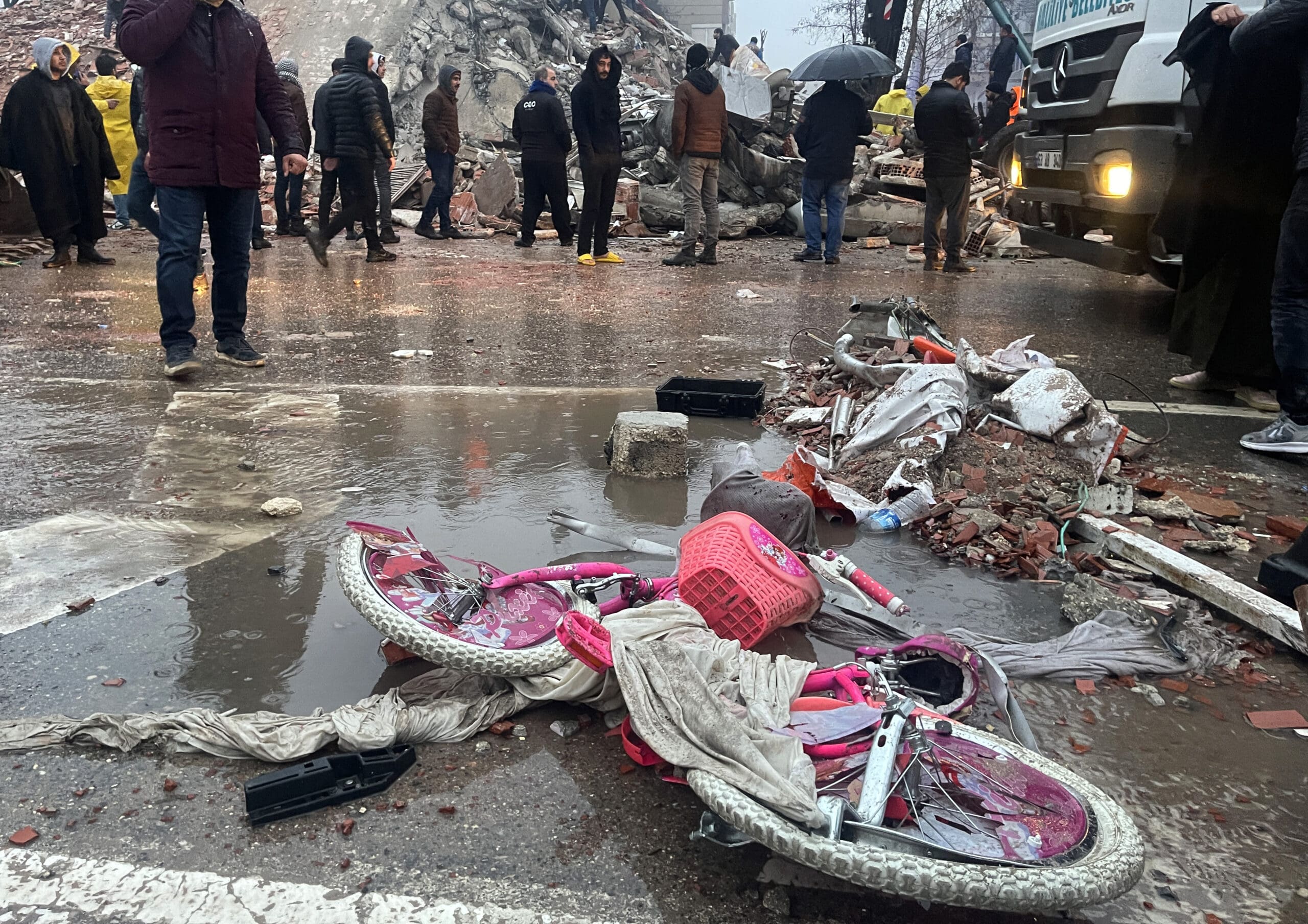 a damaged bicycle as rescuers search for survivors through the rubble