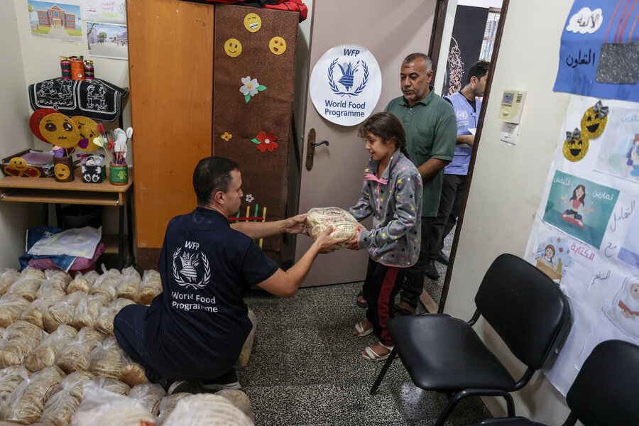 A WFP staffer hands food to a child as part of the organization's emergency response.