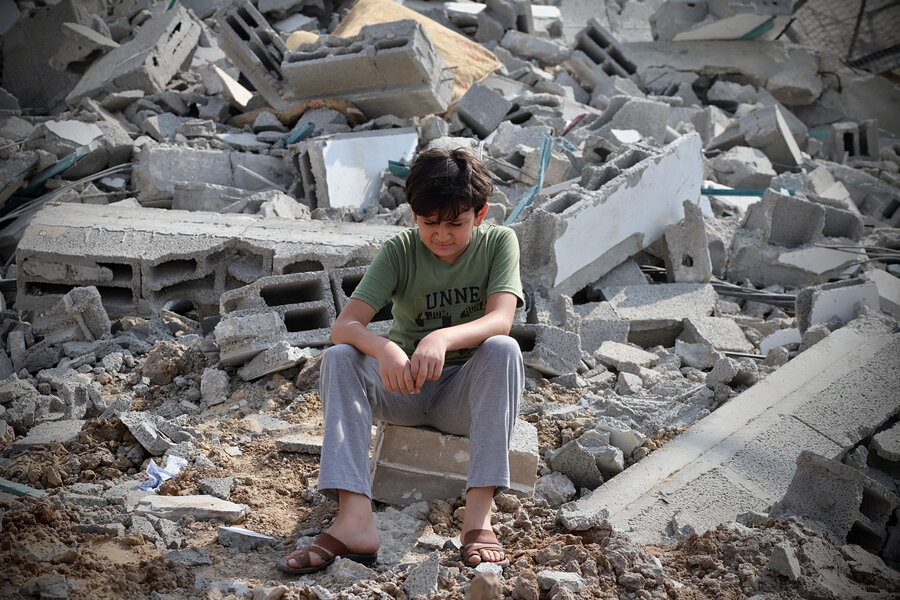 A boy sits among the ruins of a building after a rocket attack in Gaza.