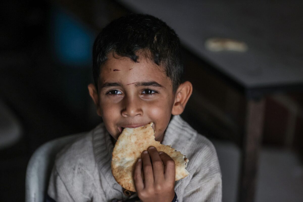 A young child takes a bite of bread