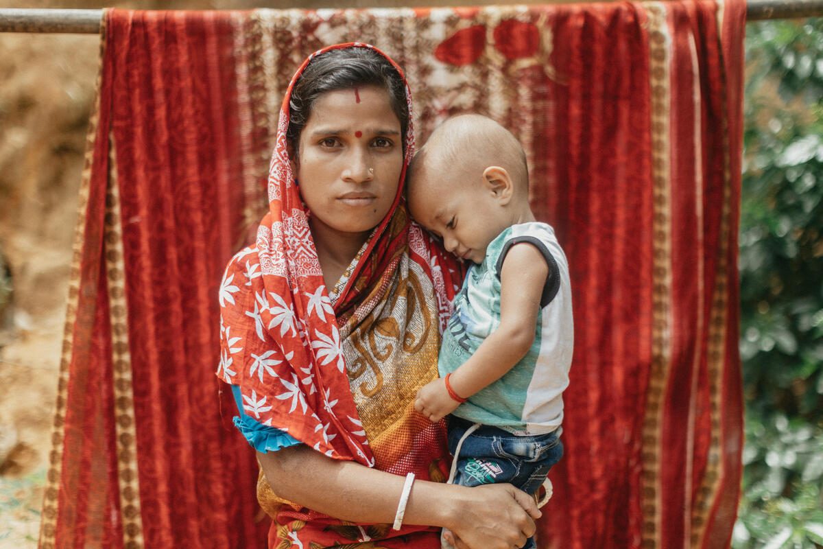 mother in red headscarf holding young boy