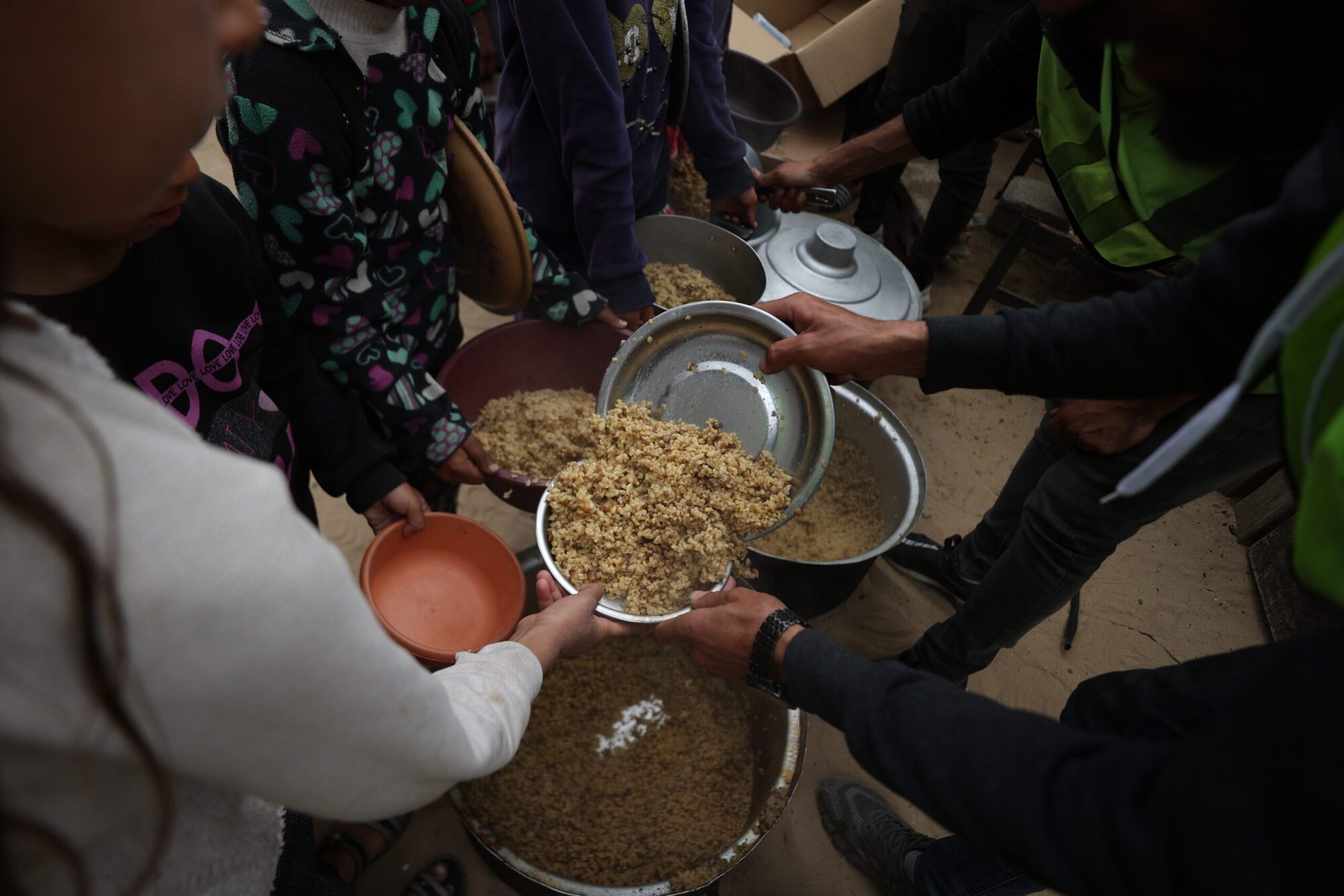 People reaching for food in Gaza